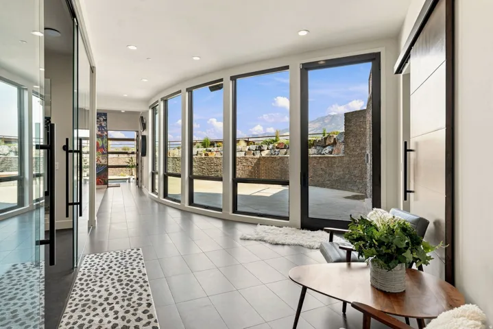 Curved wall of floor-to-ceiling windows, tile flooring, recessed lighting, and a modern barn door