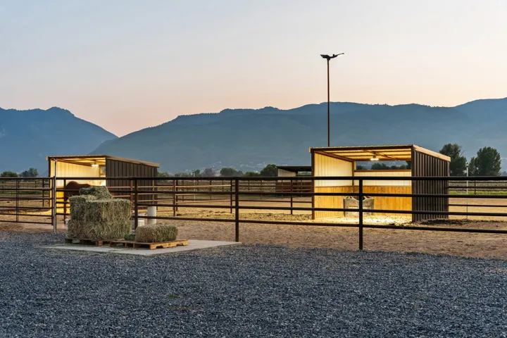 Equine facility featuring multiple stalls, extensive metal fencing, and gravel surfacing