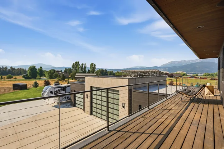 Expansive outdoor deck with wood-finish flooring and a glass panel railing