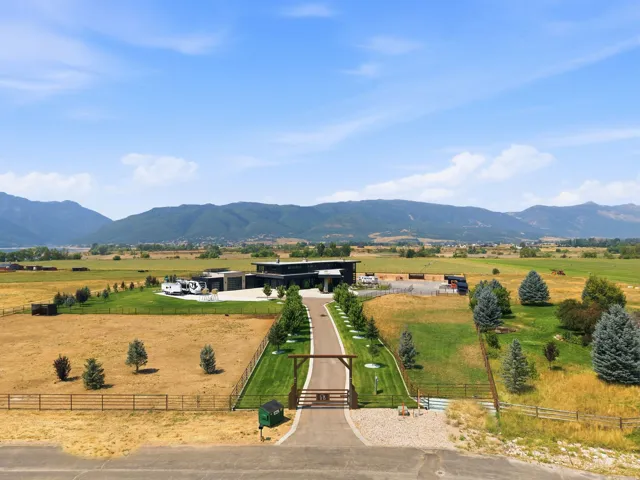 Extensive paved driveway leading to a contemporary residence with a flat roofline