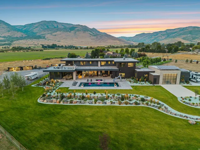 Modern exterior architecture with an integrated swimming pool, expansive patio, and manicured landscaping