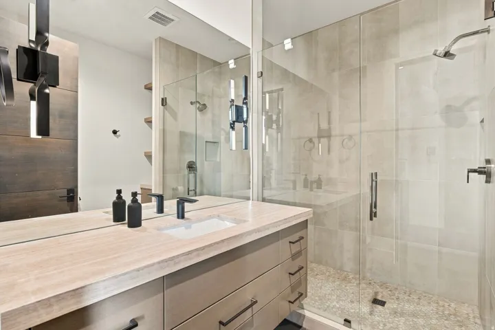 Bathroom featuring a single vanity with stone countertop, integrated sink, and dark-finish faucet