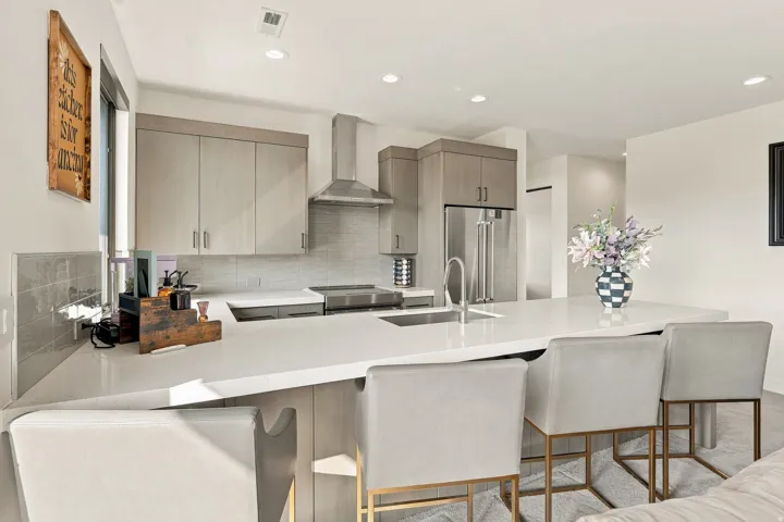 Kitchen featuring light wood-finish cabinetry, stainless steel appliances, a large center island with a sink, and recessed lighting