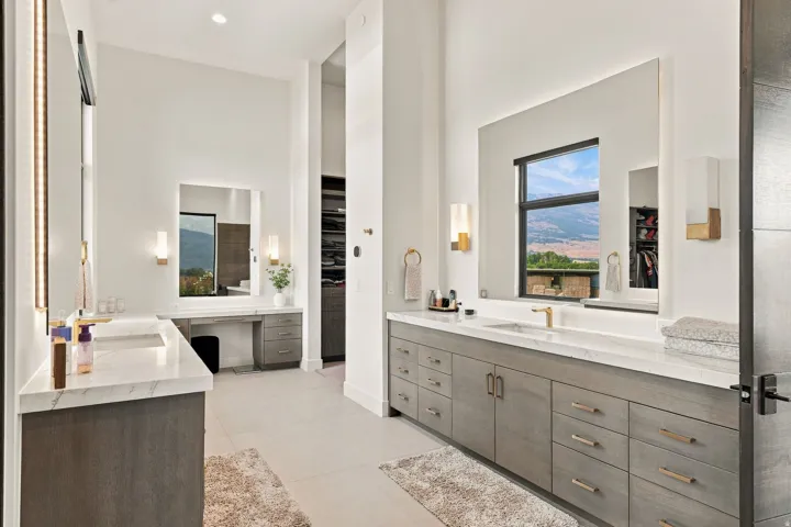 Dual vanities with integrated sinks, expansive countertops, and abundant storage cabinetry