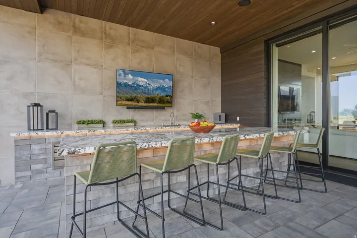 Outdoor bar with stone-finish base, integrated sink, and granite-style countertop
