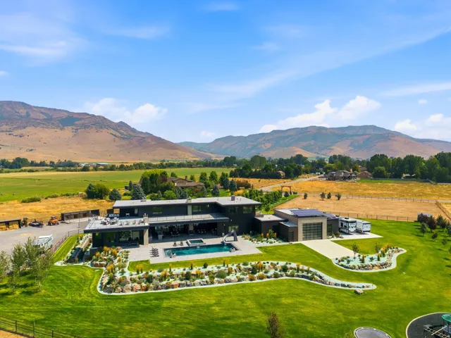 Modern exterior with a flat roofline, extensive manicured lawn, integrated swimming pool, and solar panel installation