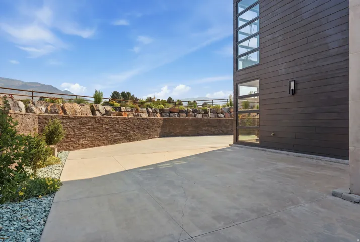Hardscaping featuring a concrete patio and stone retaining walls