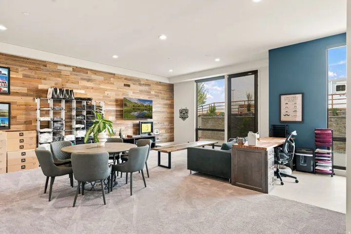 Accent wall with wood paneling, recessed lighting, expansive windows, built-in desk, and carpeted flooring