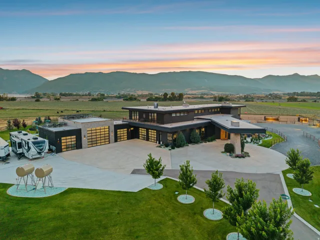 Contemporary exterior with multiple garage bays, expansive paved driveway, and established landscaping