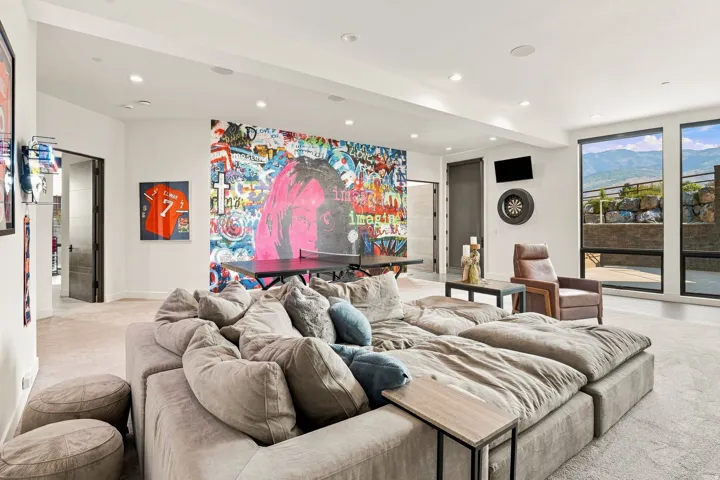Expansive recreation room featuring recessed lighting, a built-in dartboard, and large windows with mountain scenery