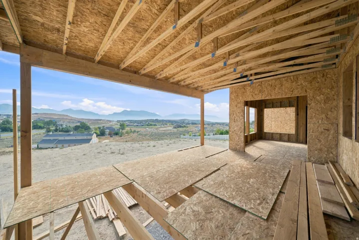 Large covered patio deck with views of the Wasatch Mountains and a large yard