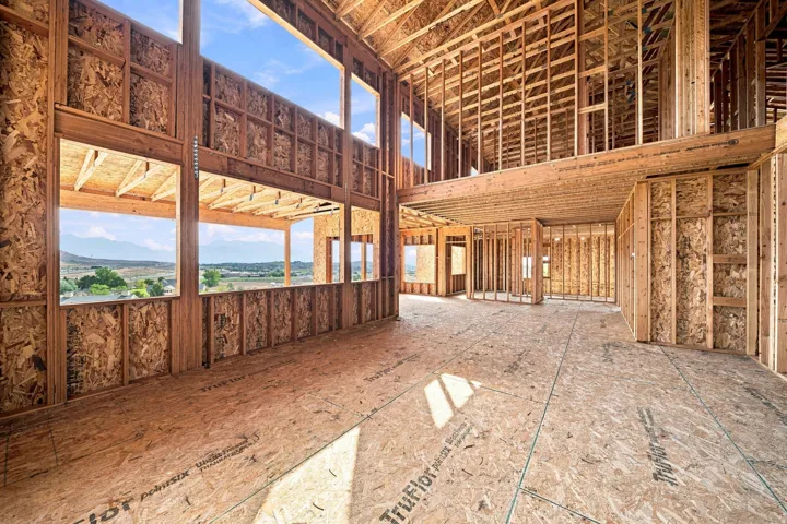Expansive open-concept interior with soaring ceilings, large multi-pane windows framing scenic landscape vistas