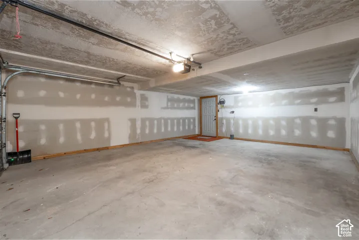 2984 - Expansive garage with concrete flooring, exposed ceiling beams, and overhead lighting
