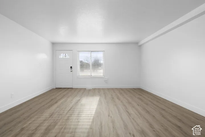 2984 - Clean interior with wood-finish flooring, white walls, and a window with blinds