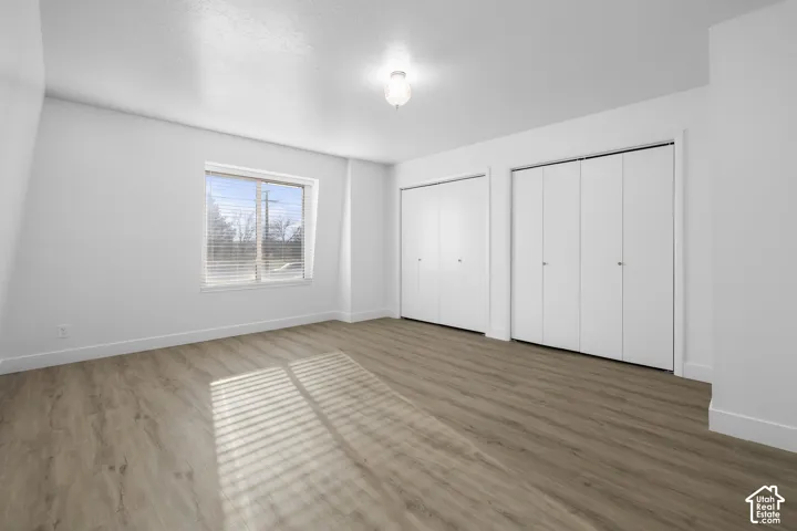2984 - Neutral white walls, wood-finish flooring, and two sets of bi-fold closet doors