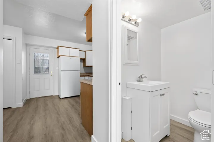 2986 - Compact bathroom with a white vanity, integrated sink, and wall-mounted mirror