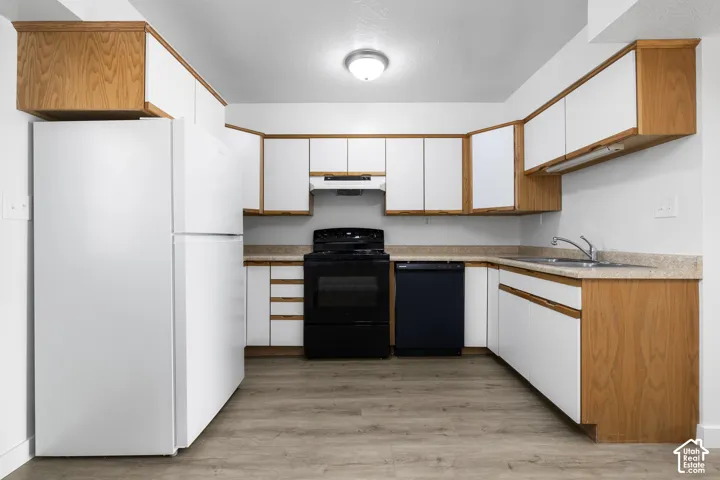 2986 - U-shaped kitchen with wood-finish and white cabinetry, a black range, a black dishwasher, and a white refrigerator