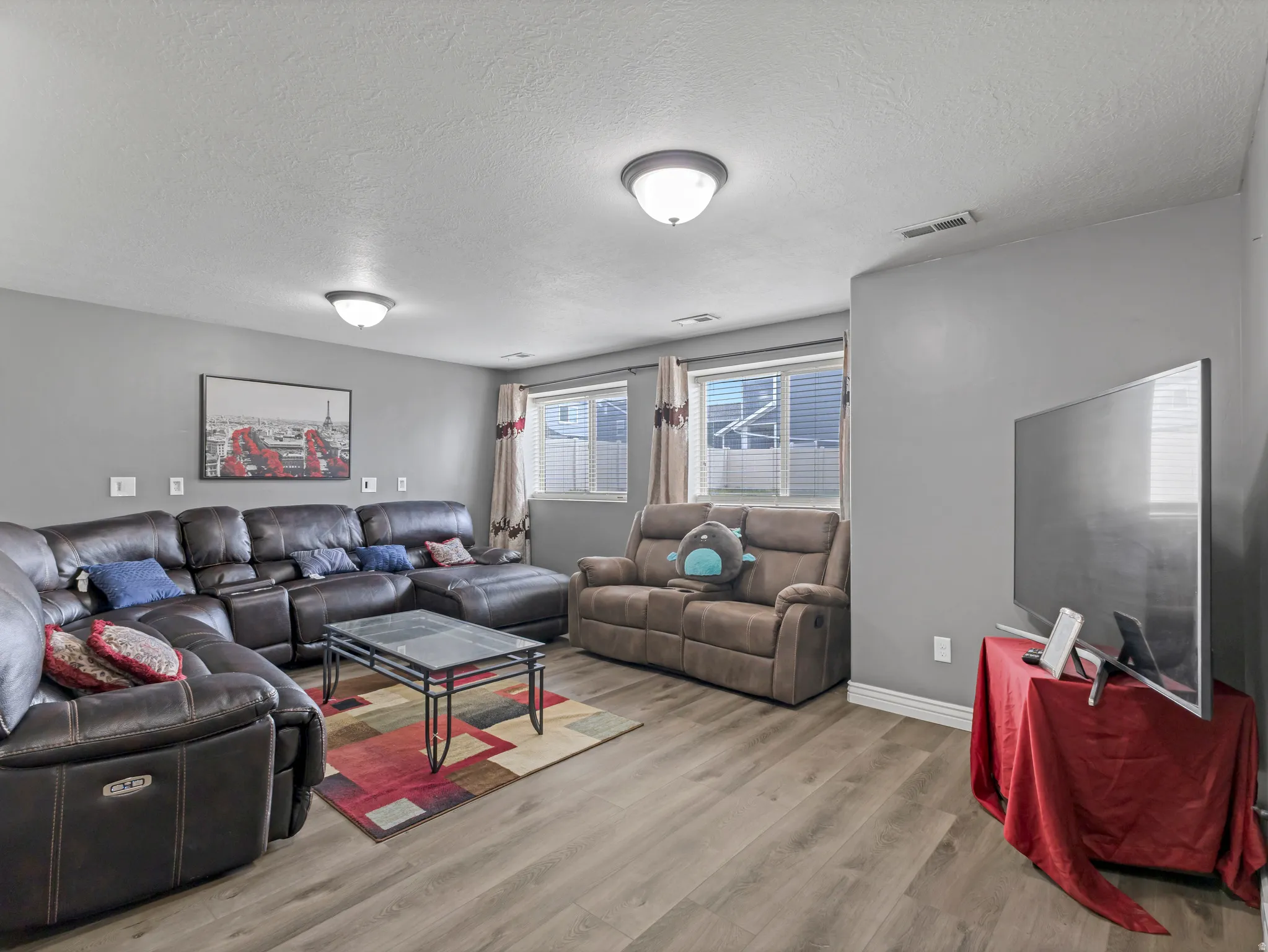 Recessed lighting, wood-finish flooring, and multiple windows with blinds