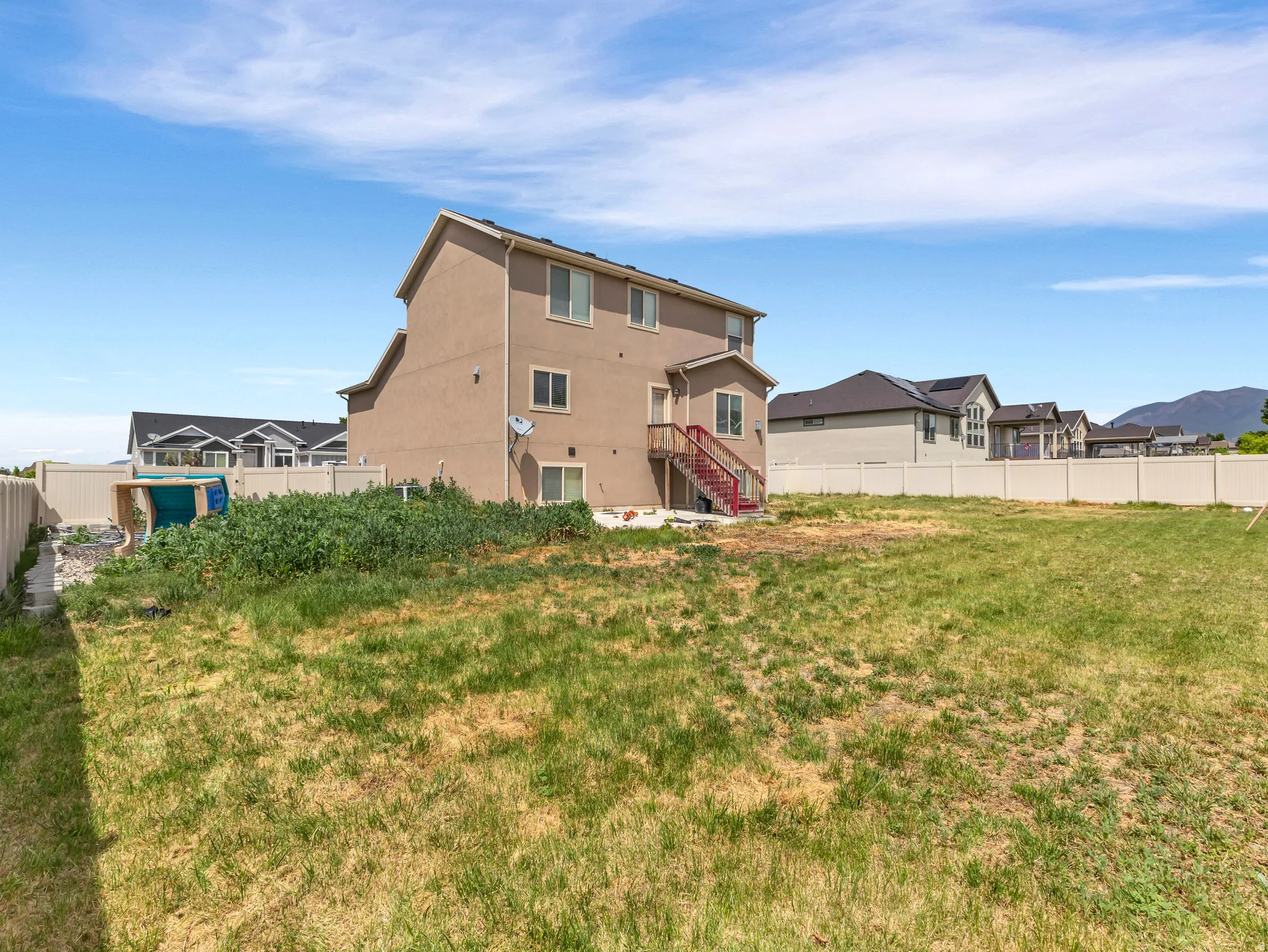 Large grassy yard with a vinyl privacy fence