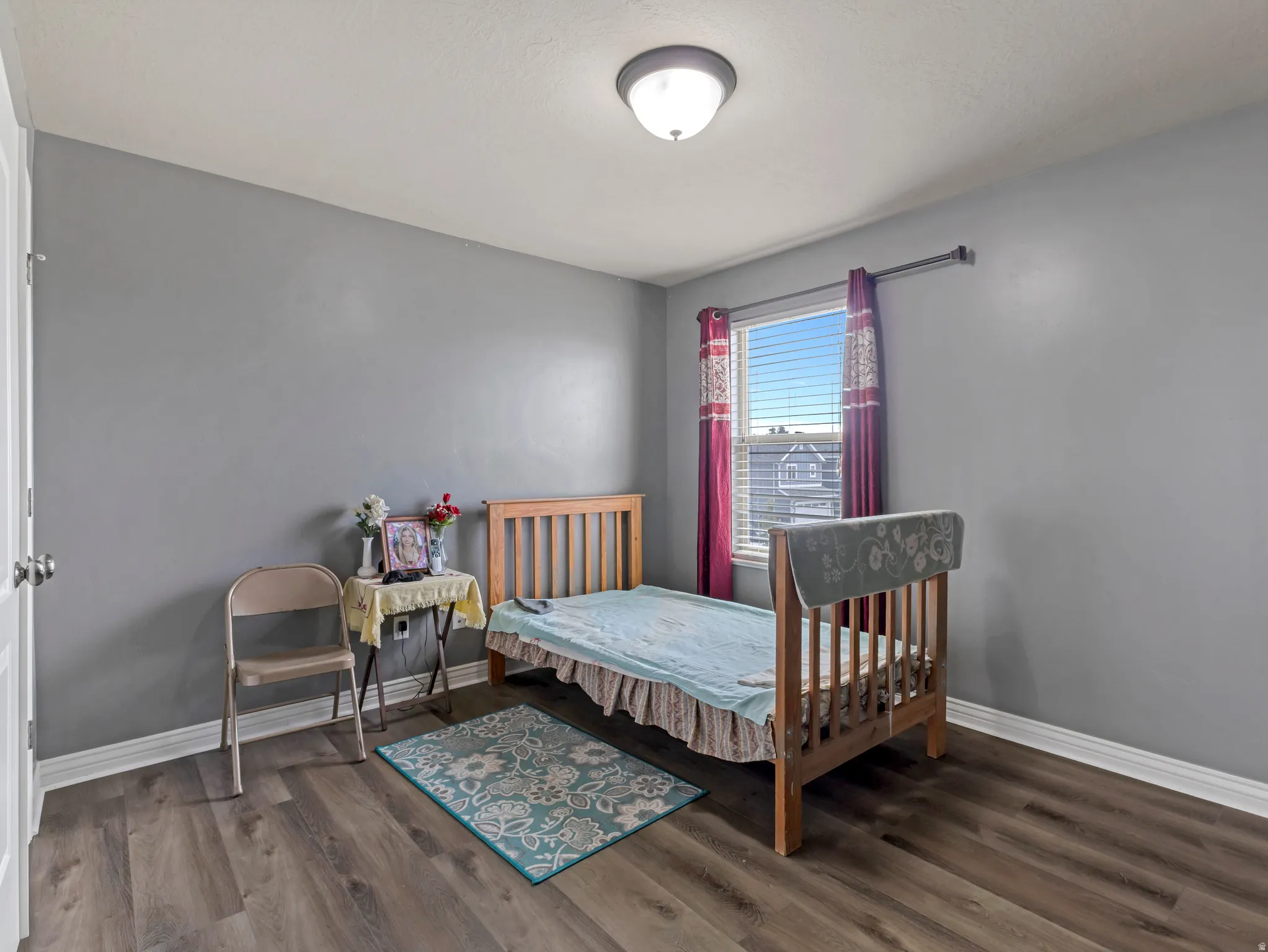 Wood-finish flooring with white baseboards and light gray walls