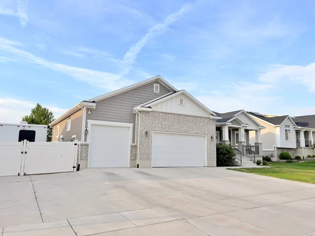 Spacious driveway with concrete finish leading to a two-car garage