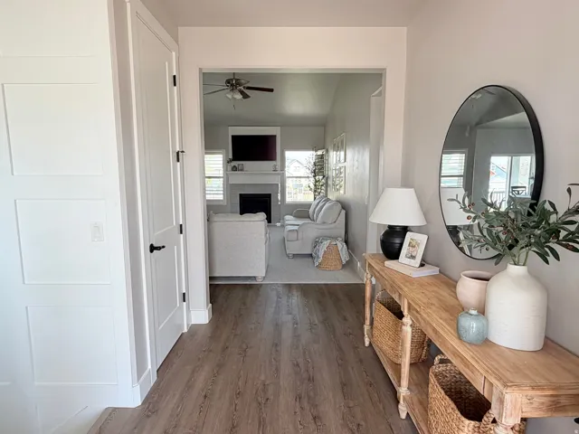 Wood-finish flooring throughout, white paneled walls, and an open entryway