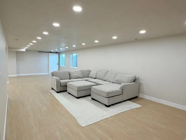 Spacious room featuring recessed lighting, light wood-finish flooring, and crisp white walls