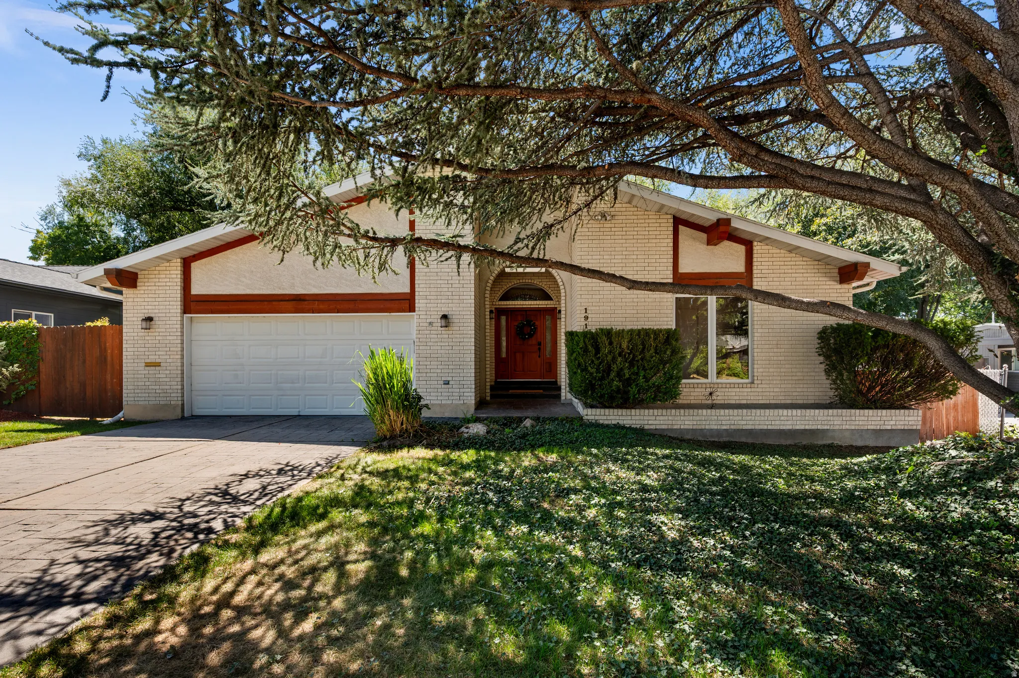 Tucked beneath a canopy of towering mature trees, this distinctive Millcreek home offers a rare combination of privacy, nature and direct access to Mill Creek.