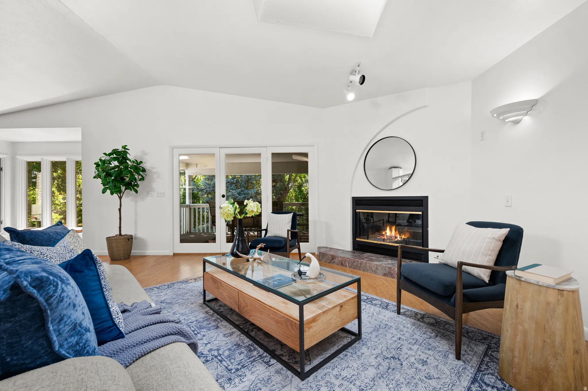 The inviting living room centers around the fireplace, with doors opening directly to the covered creekside porch.