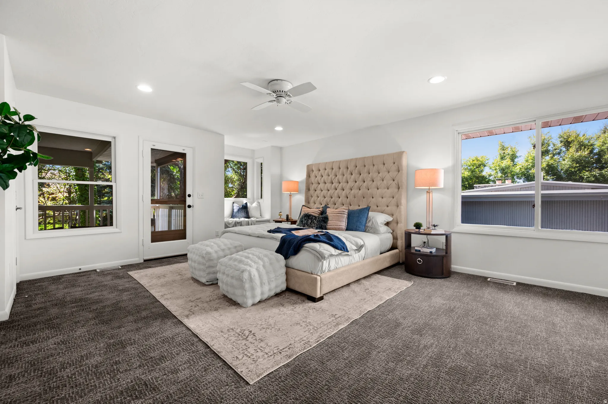 The spacious primary suite enjoys windows on multiple sides and direct access to the covered porch.