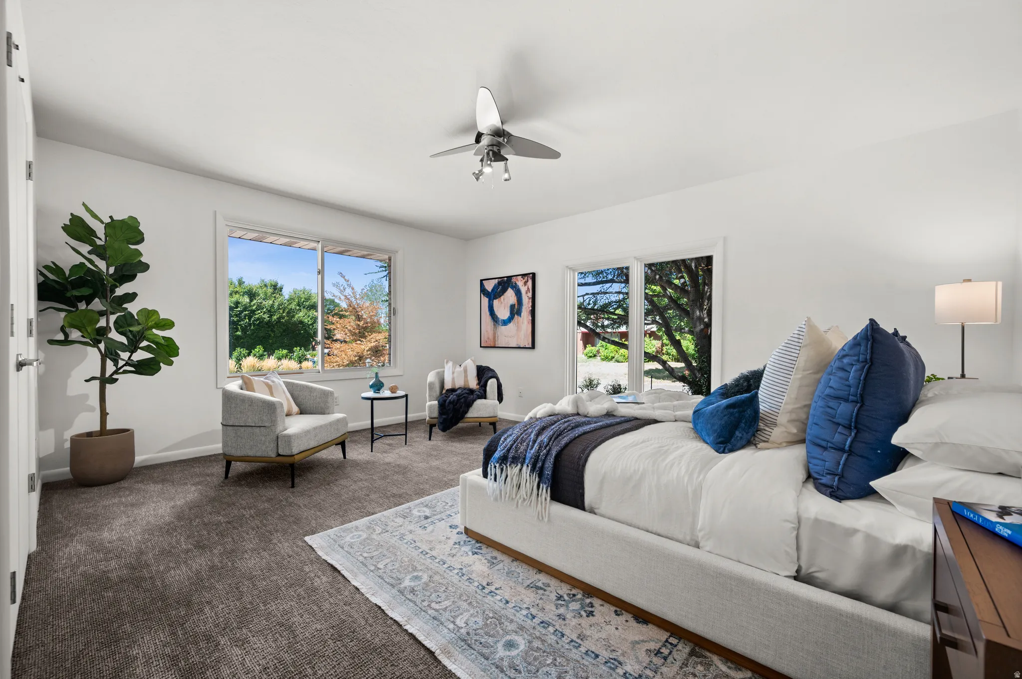 Generously sized main-level bedroom with large windows overlooking the mature landscaping.