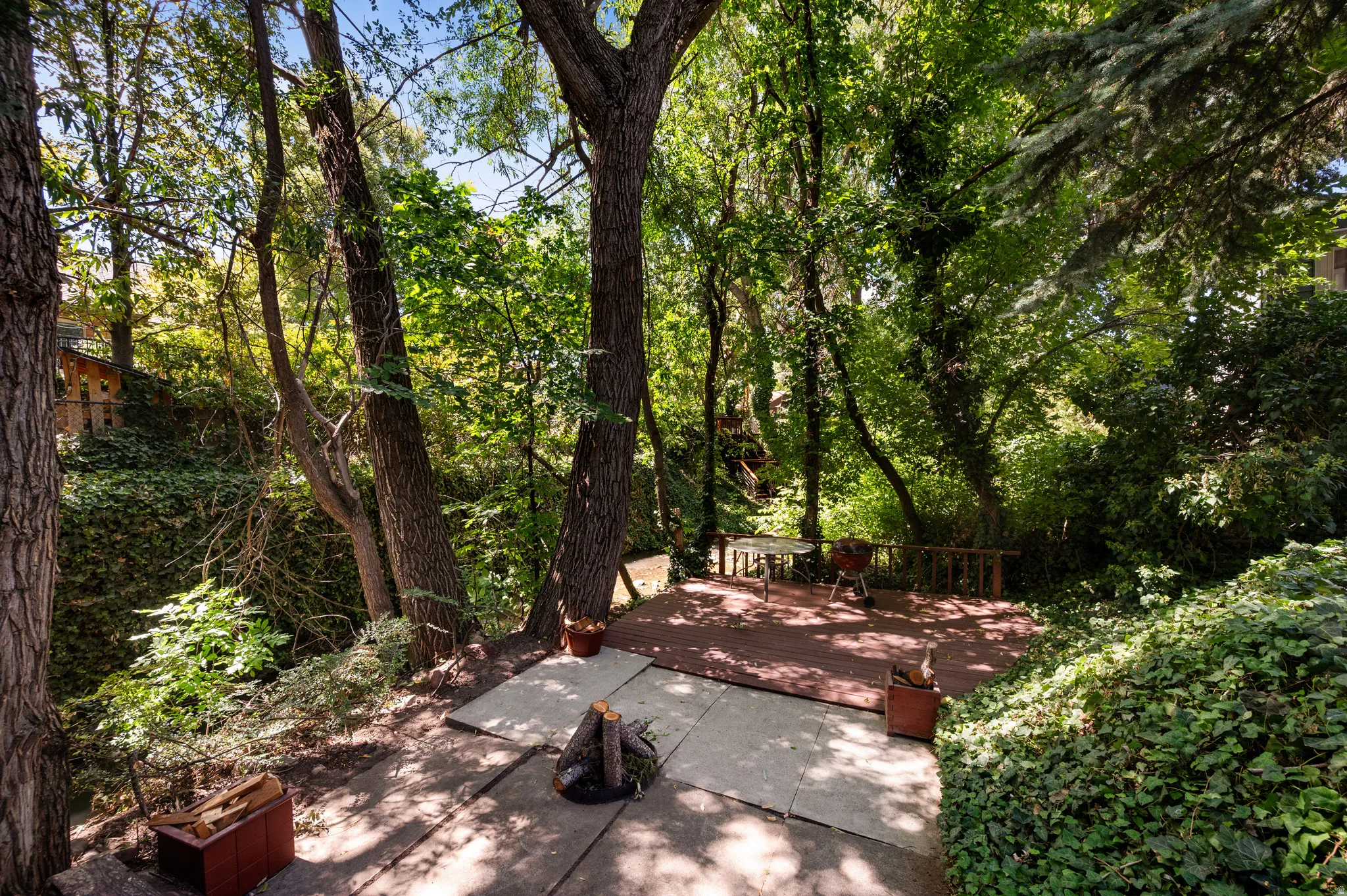 A secluded gathering area beneath the trees brings you closer to the creek and the beauty of the property.