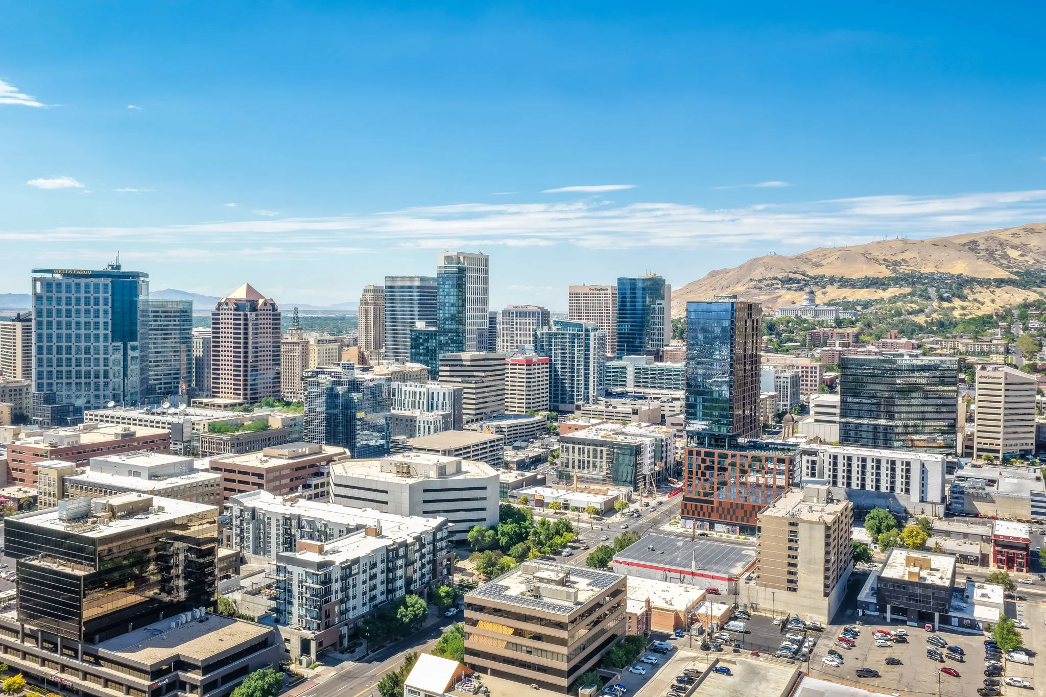 Urban skyline with various architectural styles, framed by distant hills
