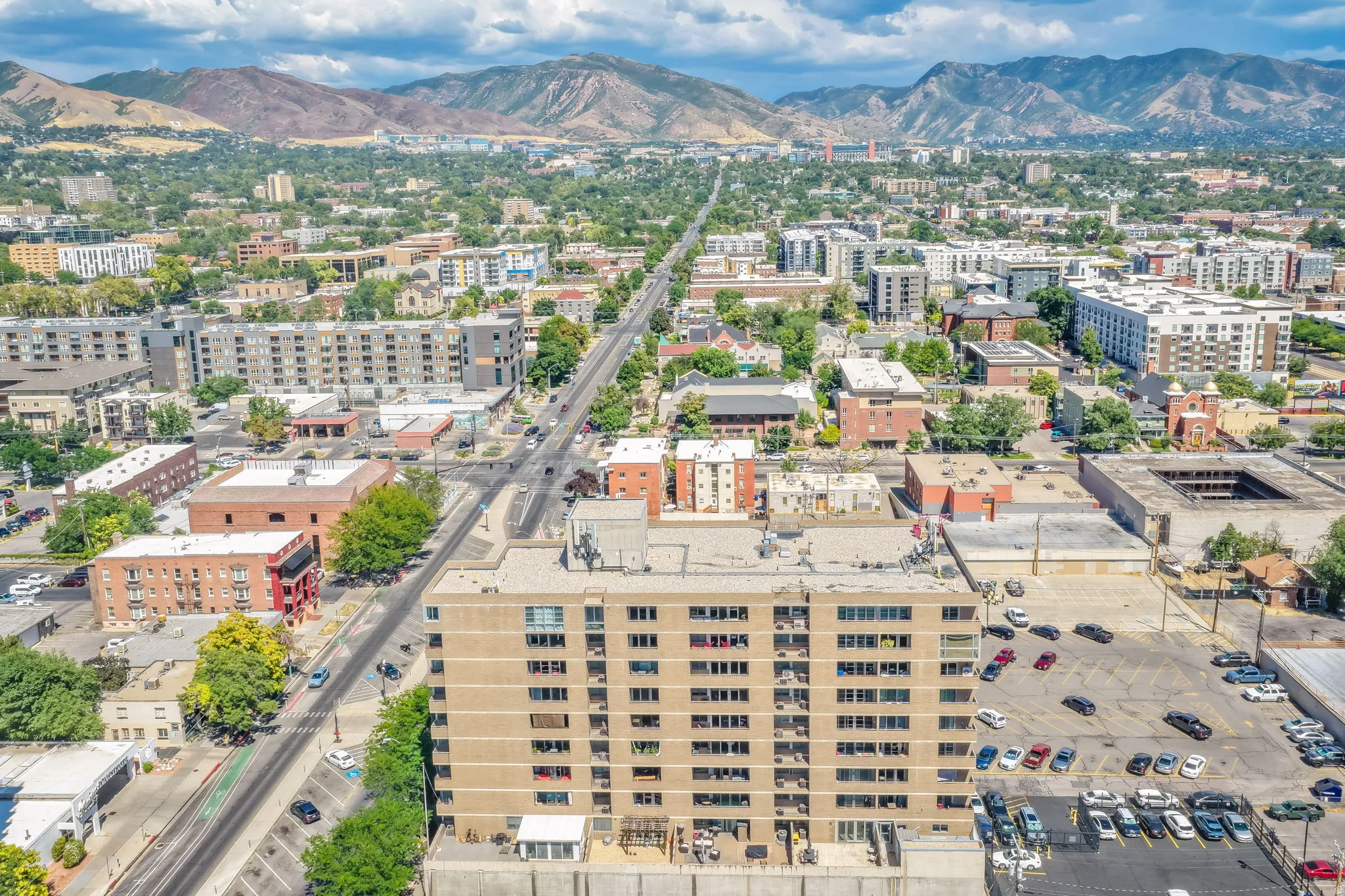 Urban setting with surrounding mountains, visible roadways, and commercial structures