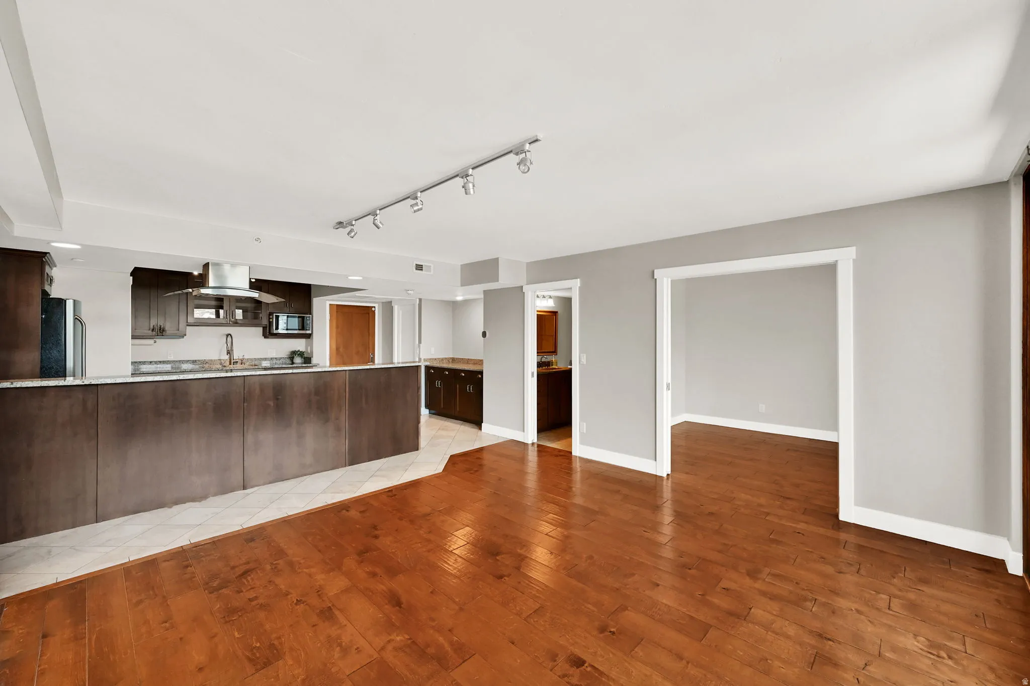 Spacious living room with large drop zone in background, by front door.
