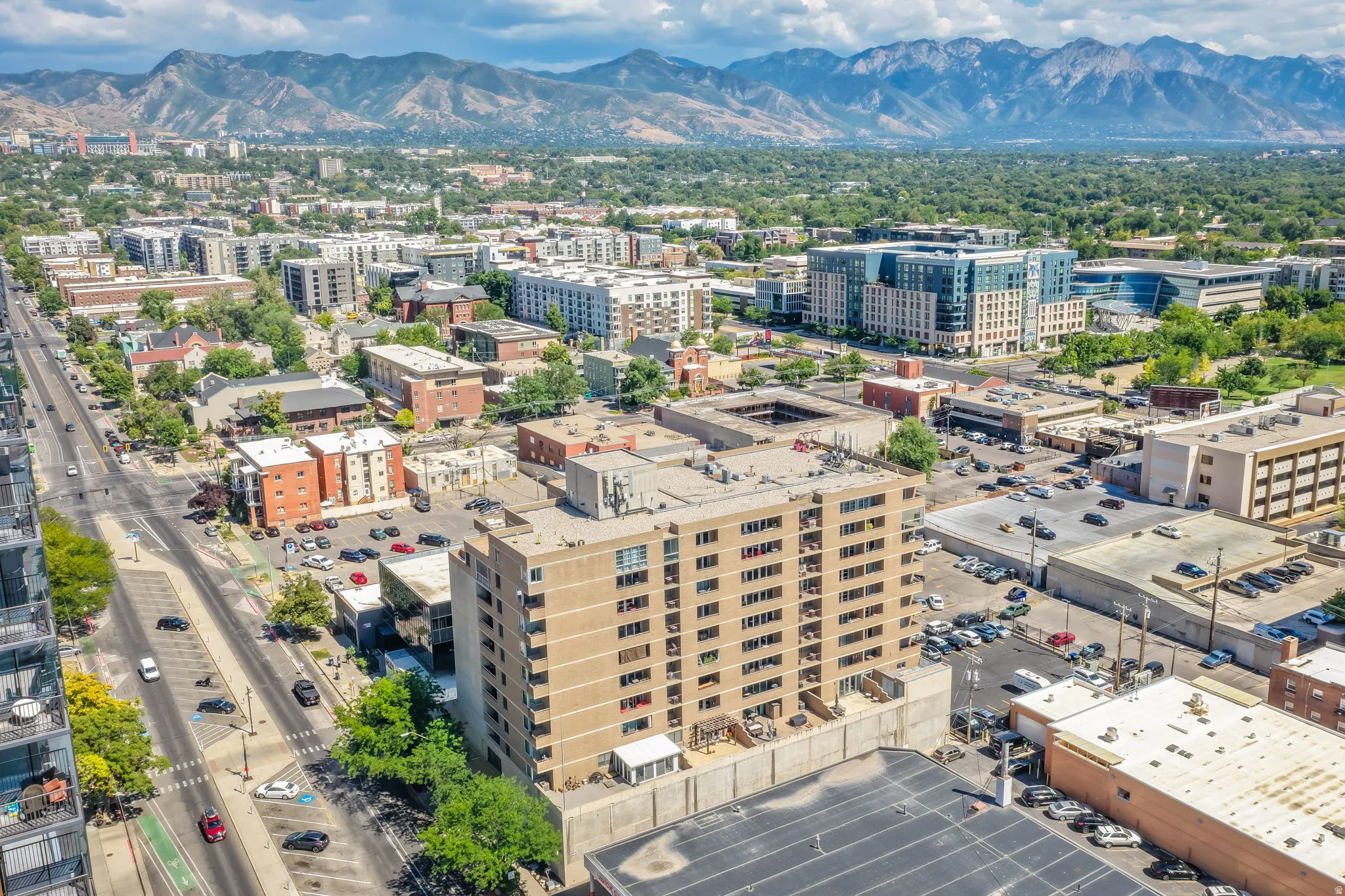 High-rise building featuring multiple balconies, rooftop amenities, and urban surroundings