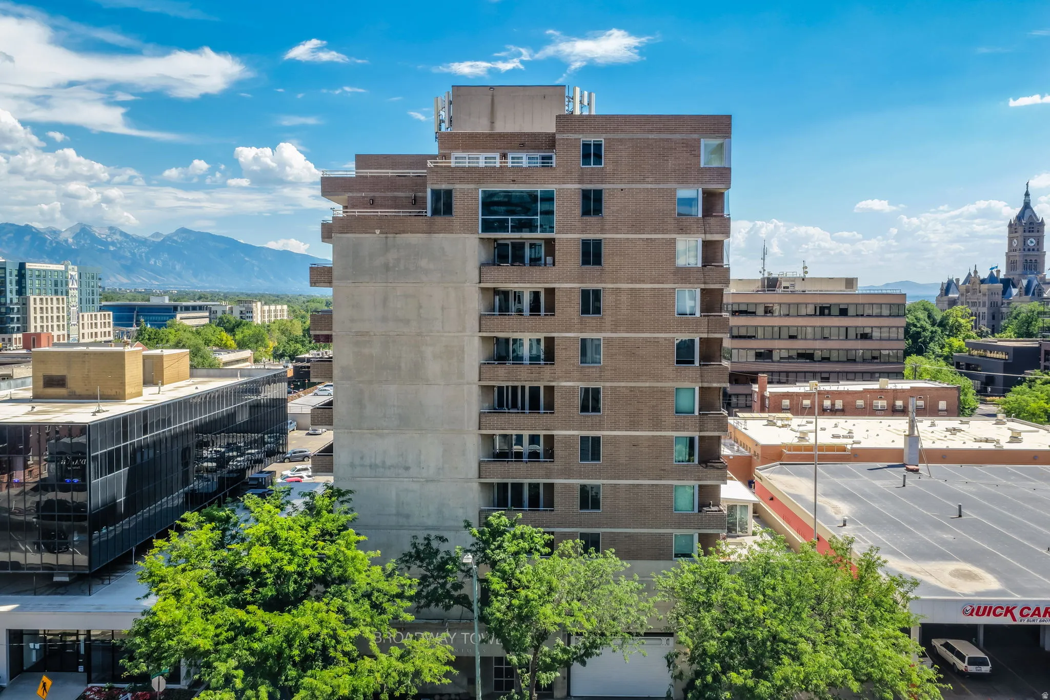 Multi-story brick building with multiple balconies and a flat roofline