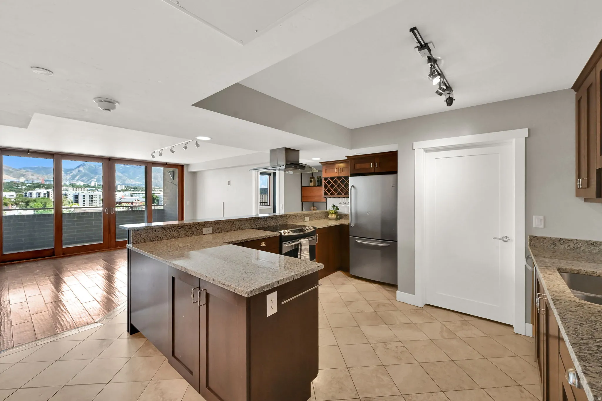 Kitchen featuring a large bar for dining with granite countertops, stainless steel appliances, and wood cabinetry