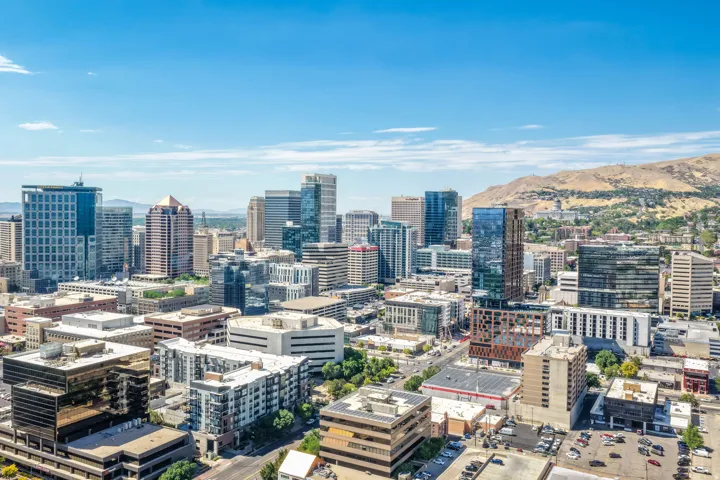 Urban skyline with various architectural styles, framed by distant hills