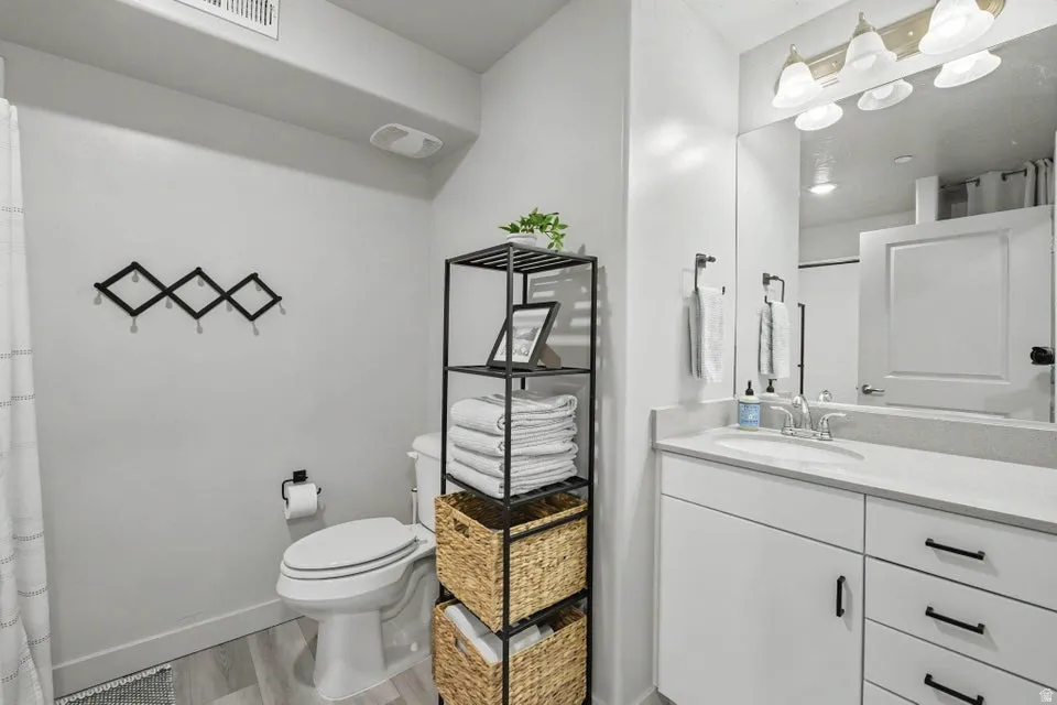 Bathroom featuring a vanity with an integrated sink, light-colored countertop, and storage cabinetry
