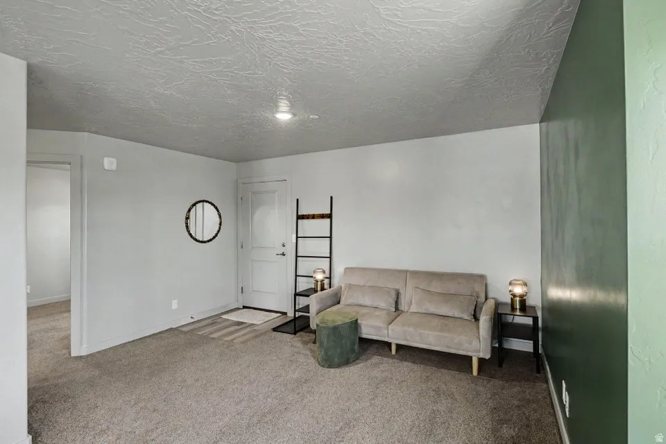 Textured ceiling, recessed lighting, neutral wall paint, accent wall, and carpet flooring