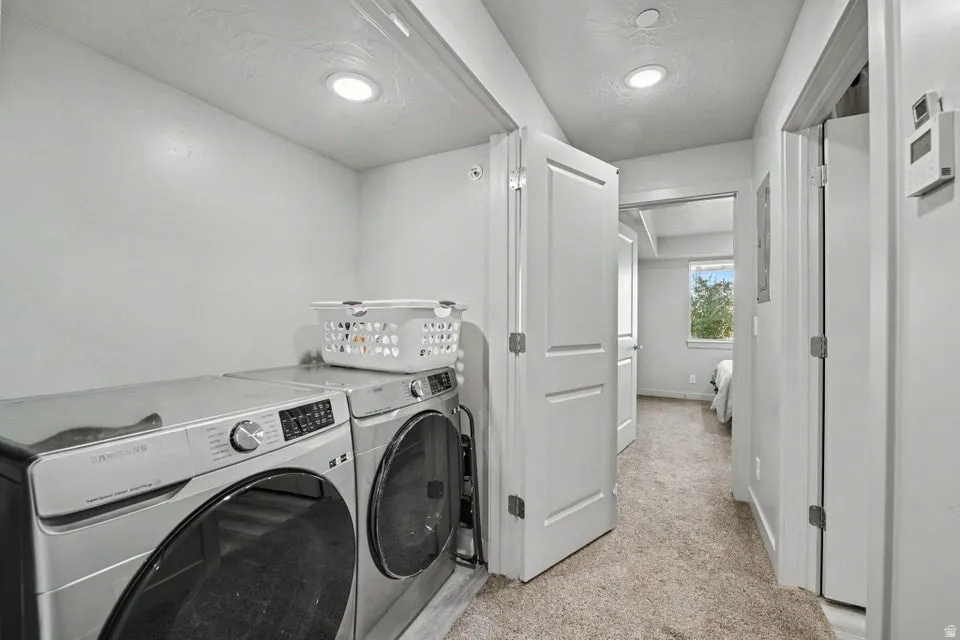Dedicated laundry area with recessed lighting, full-size appliances, and panel doors