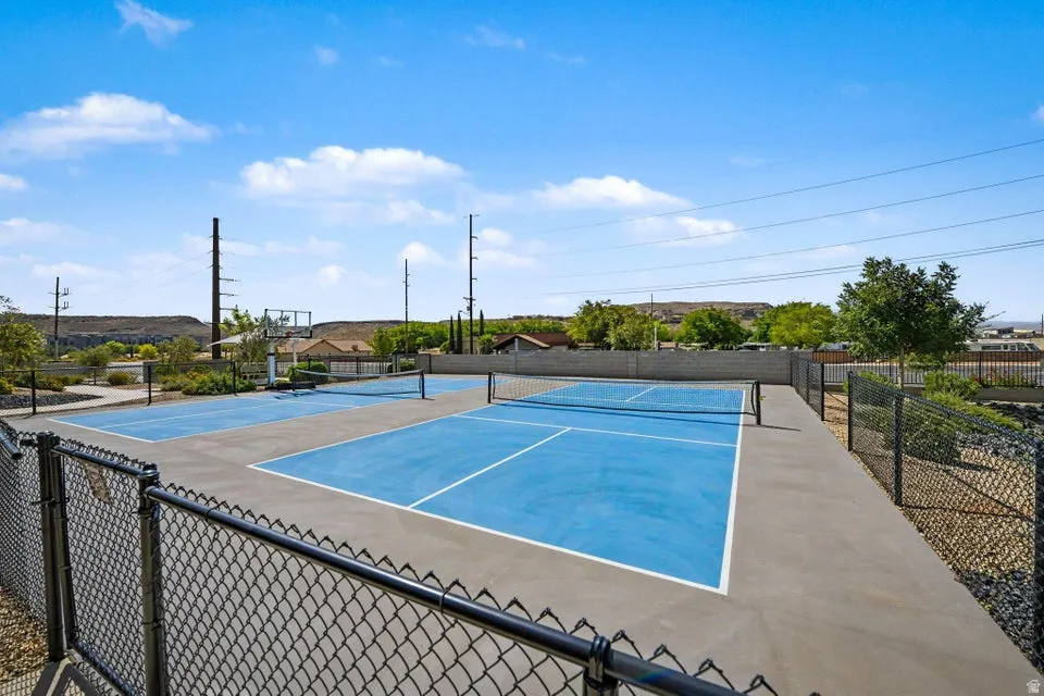 Two fenced blue pickleball courts with concrete surrounds