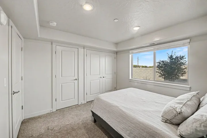Recessed lighting, large window with ample light, neutral-toned carpeting, and white paneled doors