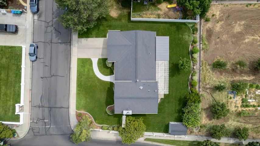 Expansive lot featuring a large lawn, a detached shed, a rear patio with a pergola, and mature landscaping