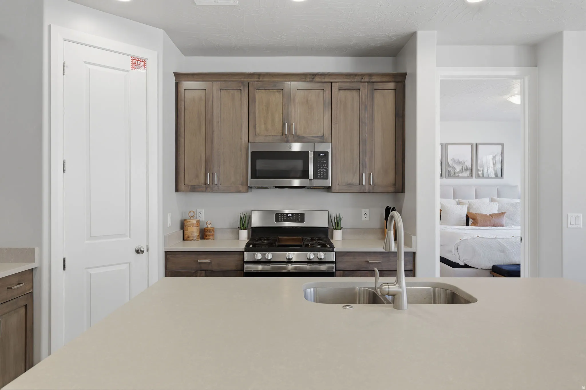 Kitchen featuring a large island with an undermount sink, stainless steel appliances, wood cabinetry, and recessed lighting