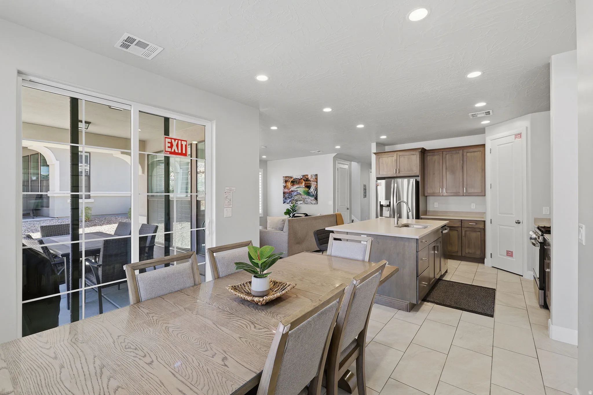 Open-concept living space featuring a kitchen island, stainless steel appliances, recessed lighting, and tile flooring
