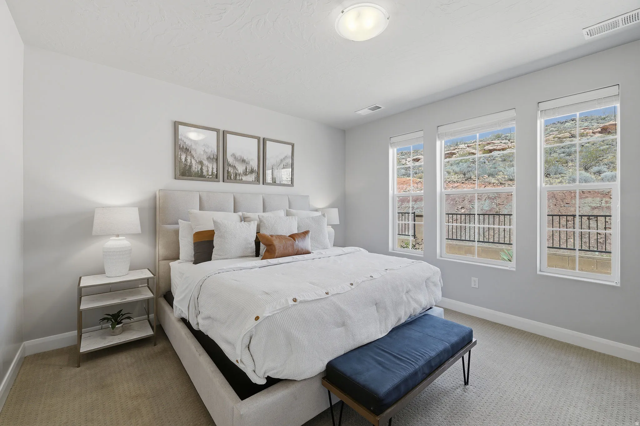 Plush carpet flooring, three large windows, white trim, and a ceiling-mounted light fixture