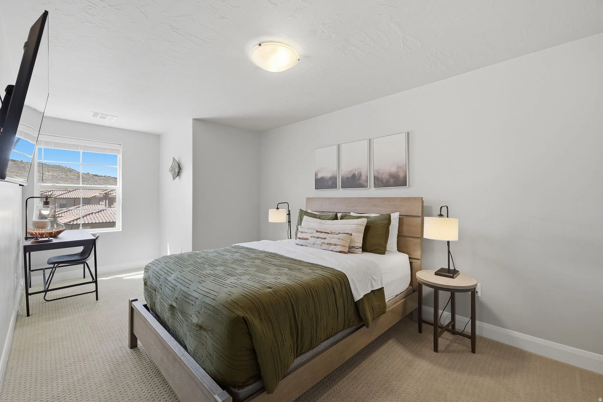 Bright bedroom featuring a wood-finish bed frame, neutral palette, and abundant natural light from large windows