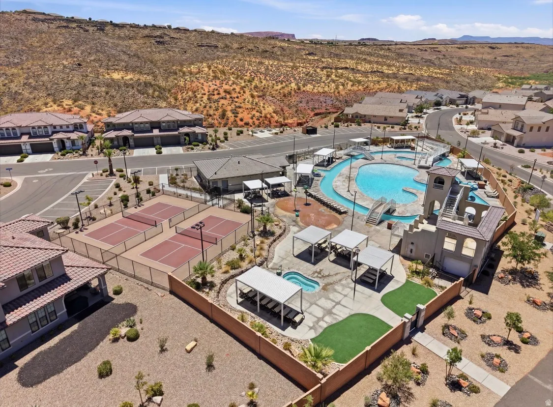Community recreation area featuring multiple tennis courts, a lazy river pool, an additional pool with a slide structure, and a separate spa